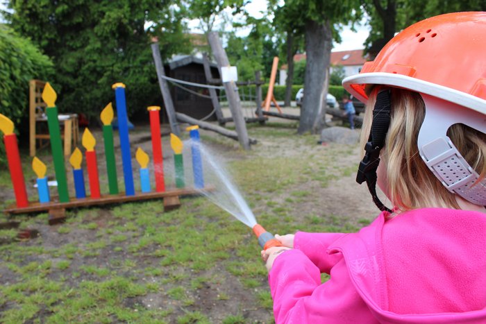 09Draussen2.JPG Kind mit Feuerspritze spritzt Figuren um