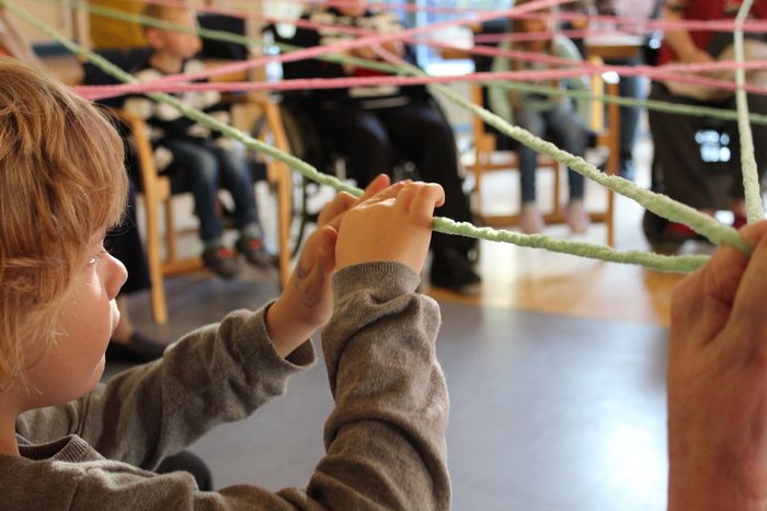 04Generaionsbruecke_1200x800.jpg im Stuhlkreis werden Fäden von Person zu Person gespannt