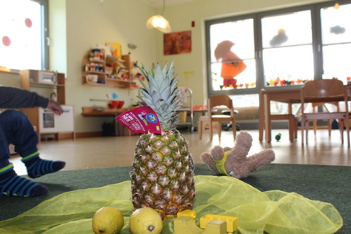 04IMG_9196_1200x800.jpg Obstteller mit ganzer Ananas im Vordergrund, Hintergrund Gruppenraum